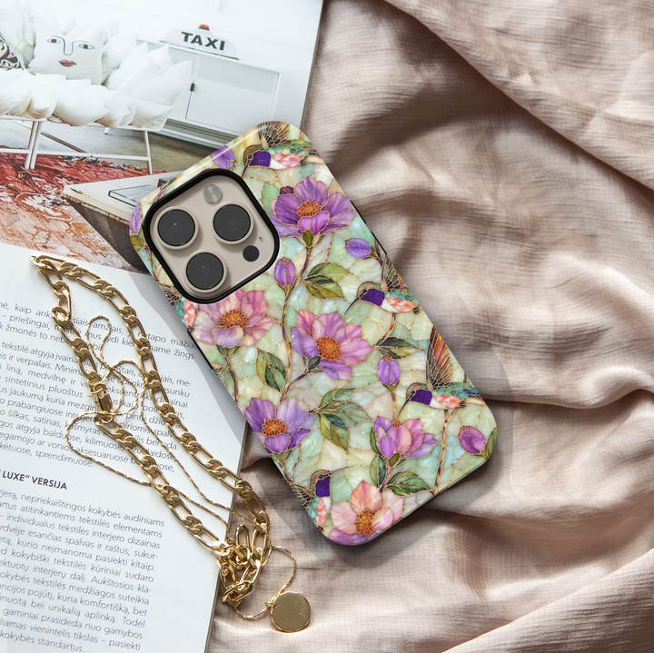 Elegant hummingbird iPhone case featuring lavender flowers, pastel blossoms, green leaves, and colorful hummingbirds with gold detailing.