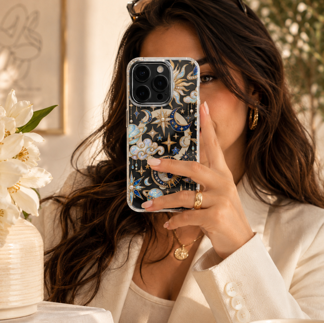 Clear MagSafe iPhone case with jeweled blue moons, opal stars, golden suns, planets, clouds and pearl celestial details.