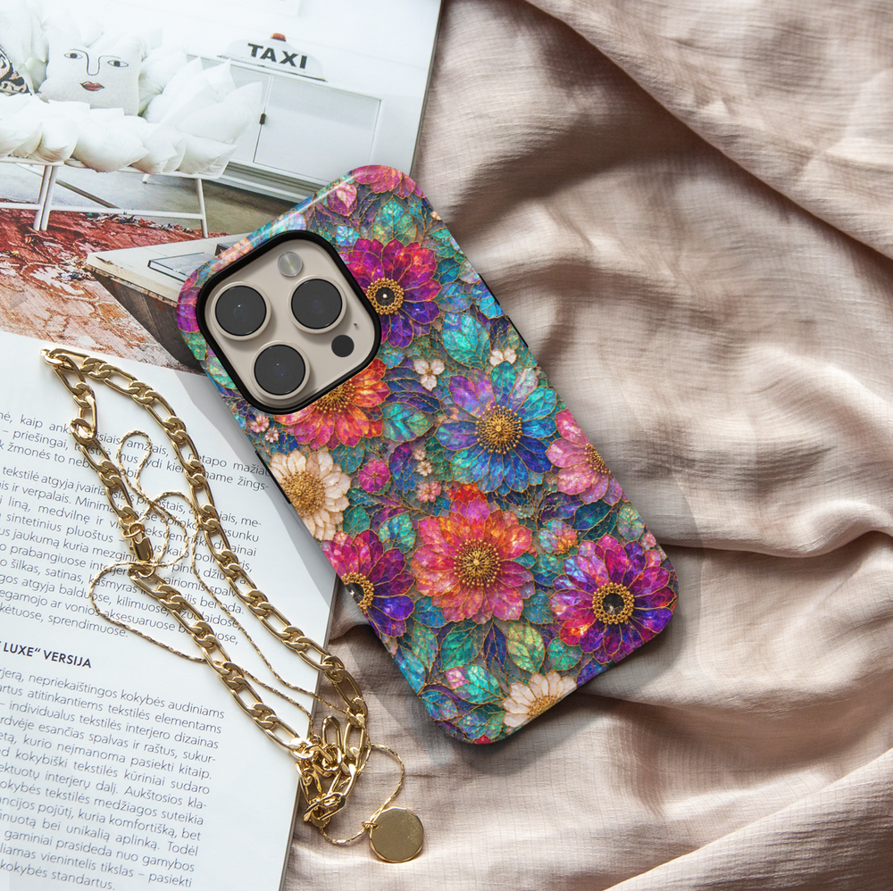 Luxury floral iPhone case featuring vibrant pink, purple, blue, and teal flowers with gold detailing and stained glass inspired artwork.