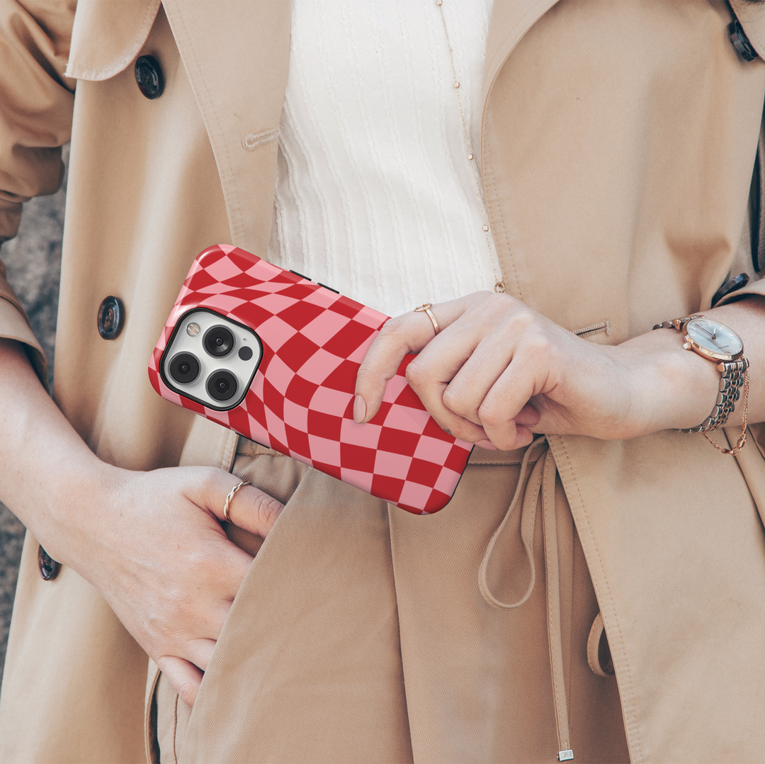 Check Mate red and pink checkerboard iPhone 18 Pro Max MagSafe case featuring a warped wavy checkered pattern in cherry red and blush pink, a cute retro protective tough iPhone 18 Pro phone case with a bold aesthetic checkerboard design and MagSafe compatibility.