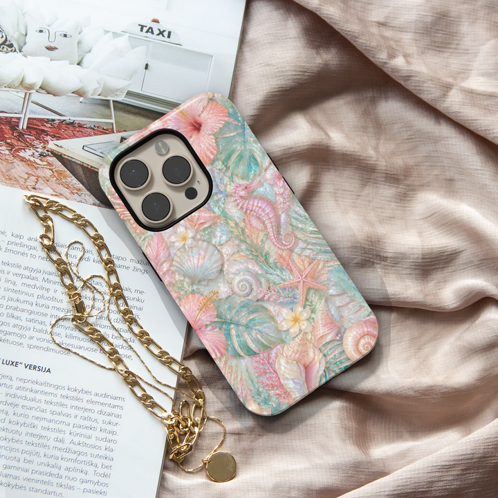 Pastel seahorse iPhone 17 Pro Max case featuring seashells, starfish, coral, tropical leaves, and luxurious coastal ocean artwork.