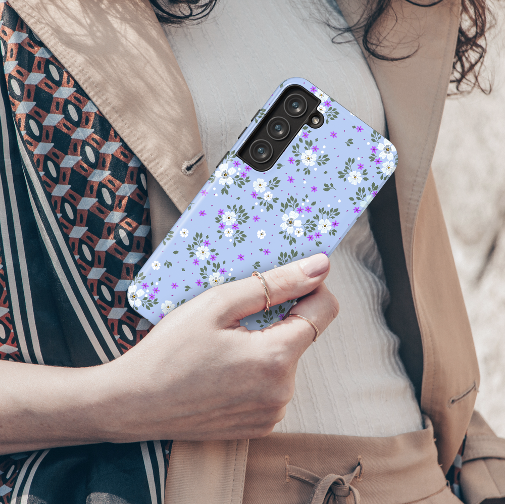 Galaxy phone case with white and purple floral pattern on light periwinkle blue background