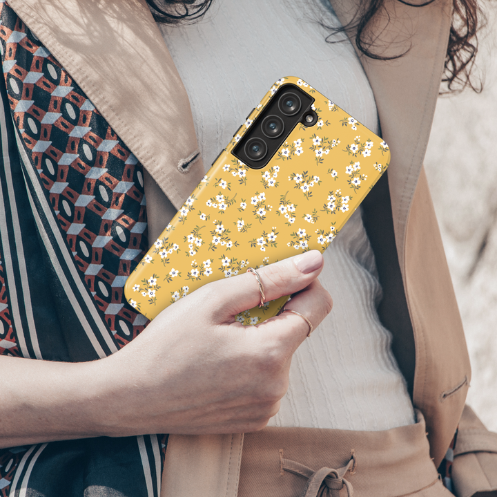 Add a pop of sunshine to your phone with this mustard yellow Galaxy case. Designed with petite white flowers and green leaves, it’s a fun and vibrant accessory for everyday style.