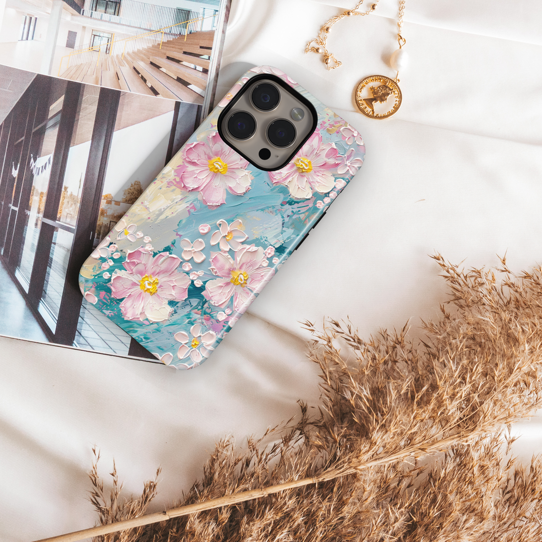 Pastel floral phone case with pink painted blossoms and textured brushstroke background in blue and cream tones