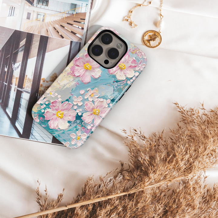 Pastel floral phone case with pink painted blossoms and textured brushstroke background in blue and cream tones